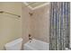 Small tiled bathroom with a bathtub and shower combination featuring a blue patterned curtain at 2740 Heritage Bend Sw Ct, Grayson, GA 30017