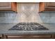 Granite counters surround the gas cooktop with decorative tile backsplash in this modern kitchen at 2740 Heritage Bend Sw Ct, Grayson, GA 30017