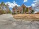 Charming brick home featuring a landscaped front yard, mature trees, and a curved driveway at 2740 Heritage Bend Sw Ct, Grayson, GA 30017