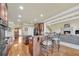 An open-concept kitchen shows an island bar, wood floors, and access to the living area and dining at 2740 Heritage Bend Sw Ct, Grayson, GA 30017