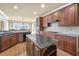 Open kitchen with a center island, stainless appliances, hardwood floors, granite counters, and wood cabinets at 2740 Heritage Bend Sw Ct, Grayson, GA 30017