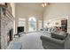 Cozy living room featuring a stone fireplace, plush gray sofas, and abundant natural light at 2740 Heritage Bend Sw Ct, Grayson, GA 30017