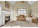 Bright sitting room with a fireplace, vaulted ceiling, and comfortable seating at 2740 Heritage Bend Sw Ct, Grayson, GA 30017