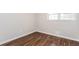 Bright, empty bedroom features beautiful wood-look floors and a large window at 4820 Oak Grove Dr, Cumming, GA 30040
