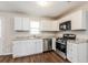 Modern kitchen featuring stainless steel appliances, white cabinetry, and granite countertops at 4820 Oak Grove Dr, Cumming, GA 30040