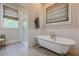 Elegant bathroom features a soaking tub and tiled walk-in shower with natural light at 124 White Oak Trl, Cumming, GA 30028
