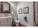 Cozy powder room with wooden framed mirror, vanity, toilet, and wood floors at 124 White Oak Trl, Cumming, GA 30028