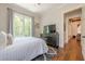 This bedroom is well-lit and has hardwood floors, a horse painting, and a television at 124 White Oak Trl, Cumming, GA 30028