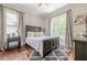 This cozy bedroom has a large window, a ceiling fan, and hardwood floors at 124 White Oak Trl, Cumming, GA 30028