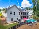 Two-story home with a walkout basement, upper porch, swimming pool, outdoor seating, and mature trees at 124 White Oak Trl, Cumming, GA 30028