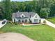 Charming two-story home with a covered porch, beautifully landscaped yard, and a circular driveway at 124 White Oak Trl, Cumming, GA 30028