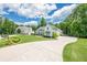 Stunning white farmhouse-style home featuring a long driveway and lush landscaping at 124 White Oak Trl, Cumming, GA 30028