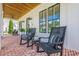 Inviting porch with brick floor, rocking chairs, and wood ceiling at 124 White Oak Trl, Cumming, GA 30028