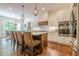 Open kitchen with wood island, stainless steel appliances, hanging lights, and wood flooring at 124 White Oak Trl, Cumming, GA 30028