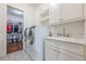 A white, modern laundry room features a laundry sink and a large washer and dryer at 124 White Oak Trl, Cumming, GA 30028