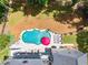 Aerial view of a private kidney-shaped pool with lounge chairs, brick patio, and mature landscaping at 124 White Oak Trl, Cumming, GA 30028