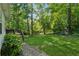 Private backyard featuring a lush lawn, mature trees, and stepping stones to the deck and home at 1679 Summit Place Way, Loganville, GA 30052