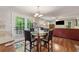 Bright breakfast area adjacent to kitchen, featuring hardwood floors, a glass-topped table, and french doors to deck at 1679 Summit Place Way, Loganville, GA 30052
