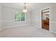 Bright, carpeted dining room with baseboard trim, large windows, and connection to kitchen at 1679 Summit Place Way, Loganville, GA 30052