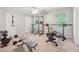 Well-equipped exercise room with multiple machines, weights, and natural light from two windows at 1679 Summit Place Way, Loganville, GA 30052