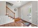Inviting foyer with hardwood floors, wooden staircase, and natural light streaming through the front door's sidelights at 1679 Summit Place Way, Loganville, GA 30052