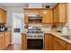 Well-equipped kitchen with stainless steel appliances, granite countertops, oak cabinets, and tiled backsplash at 1679 Summit Place Way, Loganville, GA 30052