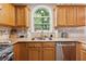 Bright kitchen featuring stainless steel appliances, granite counters, and a charming arched window over the sink at 1679 Summit Place Way, Loganville, GA 30052