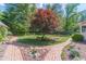 Landscaped backyard with brick pathways, lush greenery, and mature trees at 3510 Eagle Landing Dr, Snellville, GA 30039