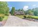 Long driveway leading to a brick home with beautiful landscaping and mature trees at 3510 Eagle Landing Dr, Snellville, GA 30039