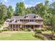 Stately brick home with a manicured lawn and charming front porch, surrounded by mature trees at 3510 Eagle Landing Dr, Snellville, GA 30039