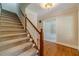 Carpeted staircase with wood railing leads to upper level; hardwood flooring on landing at 3510 Eagle Landing Dr, Snellville, GA 30039