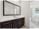 Modern bathroom featuring a dark vanity with white countertop, undermount sink and large mirror at 784 Keystone Dr, Woodstock, GA 30188