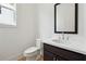 Half bathroom featuring modern sink and vanity, toilet, and crisp white walls at 784 Keystone Dr, Woodstock, GA 30188