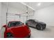 Spacious three-car garage showcasing ample parking with a red and a gray sports car at 784 Keystone Dr, Woodstock, GA 30188