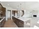A kitchen with a central island, modern appliances, dark wood cabinets, and an open view to the living room at 784 Keystone Dr, Woodstock, GA 30188