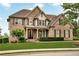 Beautiful brick home with a covered porch, manicured lawn, and professional landscaping at 1231 Ellington Ct, Cumming, GA 30041