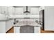 Bright kitchen with white cabinets, stainless steel appliances, and a spacious island with granite countertops and seating at 1231 Ellington Ct, Cumming, GA 30041