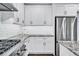 Close-up of the white cabinets, stainless steel appliances, and granite countertops in this home's gorgeous kitchen at 1231 Ellington Ct, Cumming, GA 30041