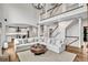 Spacious living room with a soaring ceiling, grand staircase, and modern chandelier at 1231 Ellington Ct, Cumming, GA 30041