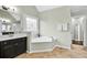 Main bathroom features a soaking tub under a decorative window and a vanity at 1231 Ellington Ct, Cumming, GA 30041