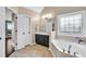 Main bathroom featuring tub with large window, tile floors, and a vanity area at 1231 Ellington Ct, Cumming, GA 30041