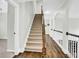 Hallway with wood and carpeted staircase with open railing and arched accents at 1231 Ellington Ct, Cumming, GA 30041