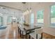 Dining room with open view to the kitchen, modern light fixture and dining table with chairs at 1273 Grayson Pkwy, Grayson, GA 30017