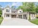 Beautiful home with white brick, stone accents, three-car garage, and long concrete driveway at 1273 Grayson Pkwy, Grayson, GA 30017