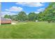 Large grassy backyard with mature trees, a detached garage, and a red deck at 1419 Gates Mill Walk, Lawrenceville, GA 30045