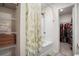 Bright bathroom featuring a shower with a leaf-patterned curtain, shelving, and a glimpse into the closet at 217 Limestone Cir, Conyers, GA 30013