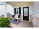 Inviting front porch with seating, complemented by a stylish rug, black door, and brick accents, offering a cozy outdoor space at 217 Limestone Cir, Conyers, GA 30013