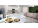 Bright kitchen features white cabinets, granite countertops, stainless steel appliances, and an adjacent dining area at 217 Limestone Cir, Conyers, GA 30013