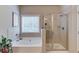 Bright bathroom features a soaking tub and a glass enclosed shower with natural light from a window at 2275 Black Pebble Cir, Buford, GA 30519