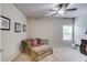 Bright bedroom featuring comfortable seating area, ceiling fan, and natural light from the window at 2275 Black Pebble Cir, Buford, GA 30519